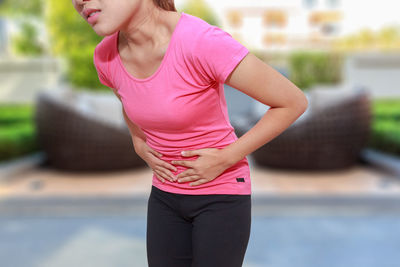 Woman suffering from stomachache while standing outdoors