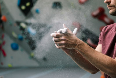 Midsection of man dusting powder in gym