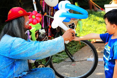 Rear view of people holding bicycle