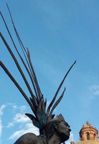 Low angle view of statue against blue sky