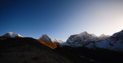 Scenic view of snowcapped mountains against clear blue sky