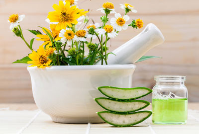 Close-up of flower in mortar and pestle by aloe vera