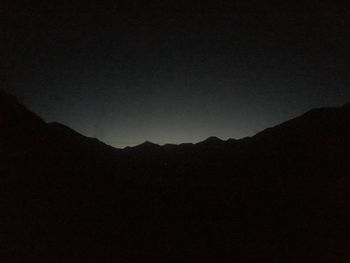 Silhouette mountains against clear sky at night