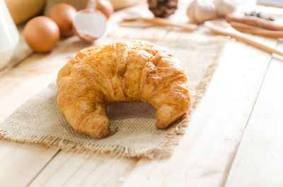 Close-up of croissant and ingredients on table