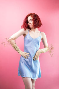 Woman in dress holds a sprig of dried flowers