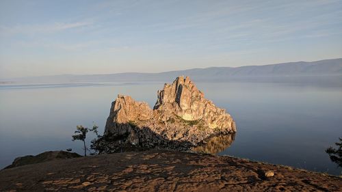 Rock formations by sea against sky