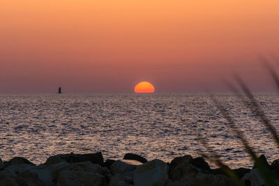 Scenic view of sea against orange sky