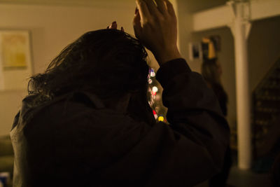 Rear view of people standing against wall