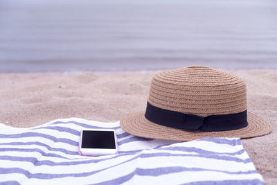 Close-up of hat on sand at beach