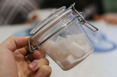 Close-up of person hand holding white container