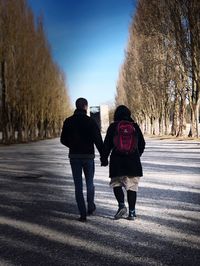 Rear view of couple walking on road