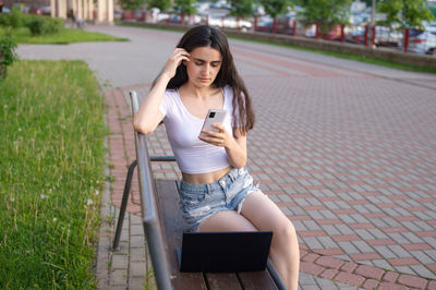 Portrait of young woman using mobile phone