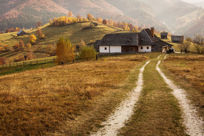 Scenic view of field by houses and mountains