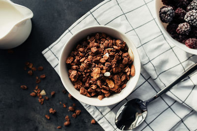 Frozen blackberries, granola, cream, towel on table. blurred background. high quality photo