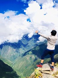 Rear view of man on mountain against sky