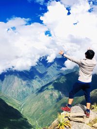 Rear view of man on mountain against sky