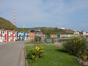 Road by buildings against sky in city