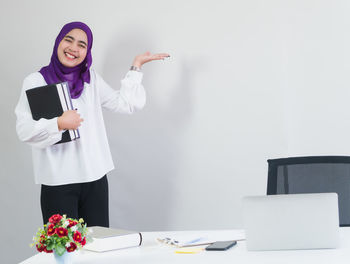 Young woman using phone while standing on table