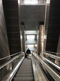 Rear view of woman on escalator