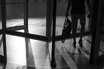 Low section of man walking on tiled floor