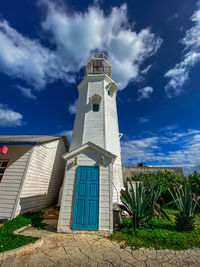 Lighthouse by sea against sky