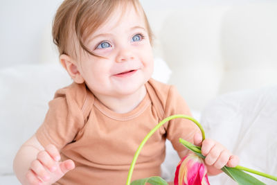 Portrait of cute baby girl with red flower