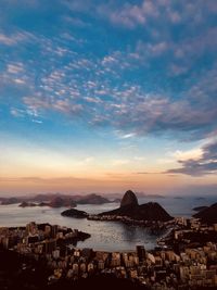 Scenic view of sea and buildings against sky during sunset