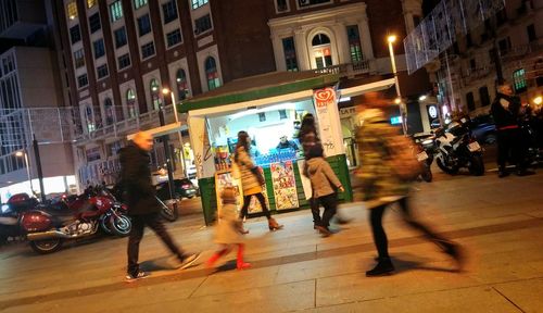 Woman walking on city street at night