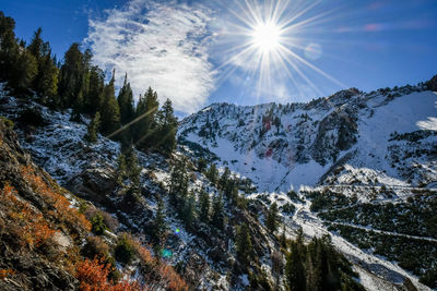 Scenic view of snowcapped mountains against bright sun