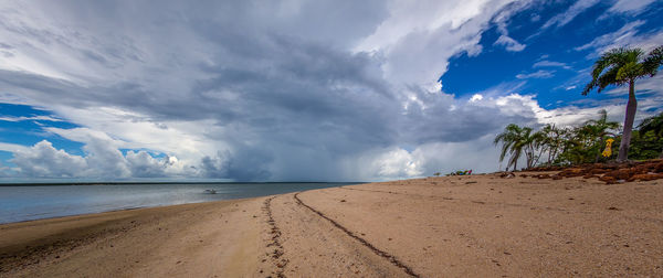 Scenic view of beach and sea against cloudy sky 