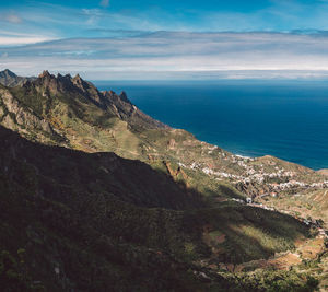 Scenic view of sea and mountains against sky