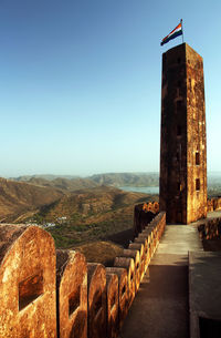 Indian flag on column at jaigarh fort against clear sky