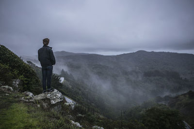 Rear view of man standing on mountain