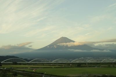 View of bridge over mountain against cloudy sky