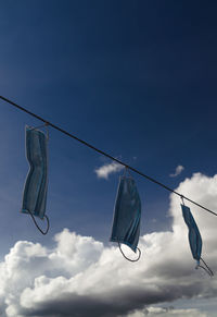 Low angle view of clothes hanging on clothesline against sky