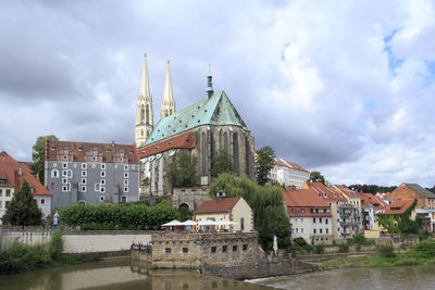 View of buildings in city against cloudy sky