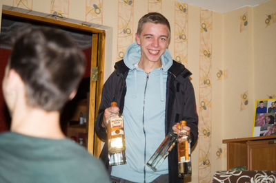 Portrait of a smiling young man drinking glass