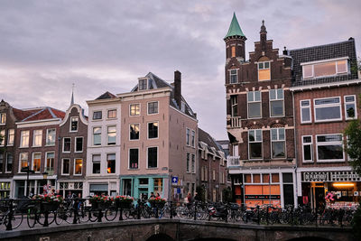 Utrecht, the netherlands. a line of bikes parked on a bridge over the oudegracht canal.