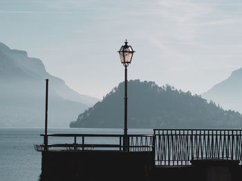 Street light by mountains against sky