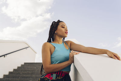 Young woman standing on staircase