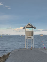 Lifeguard hut on beach against sky