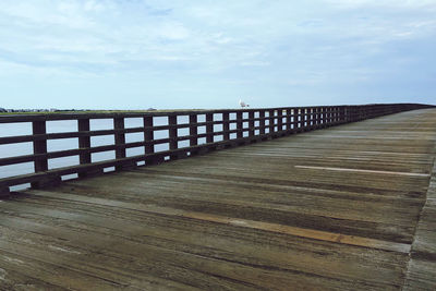 Surface level of pier over sea against sky