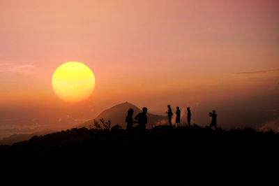 Silhouette people against sky during sunset