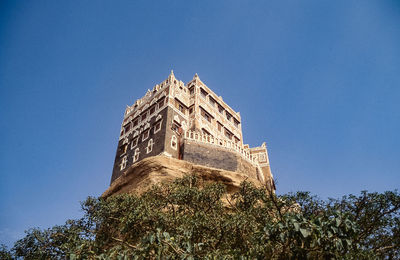 Low angle view of historical building against clear blue sky