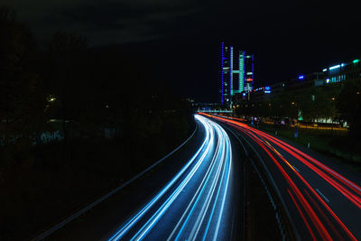 Light trails on road against sky at night