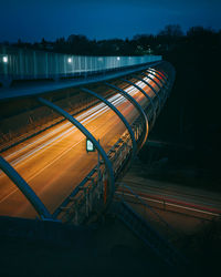 Light trails by lake against sky at night