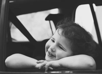 Close-up of cute girl sitting in car