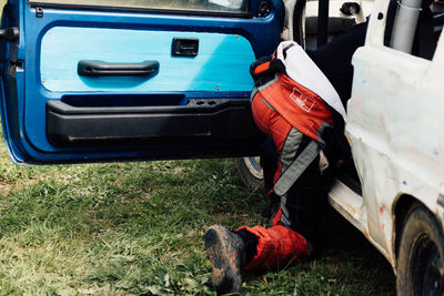 Man repairing car on field