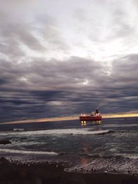 Boat sailing on sea against sky during sunset