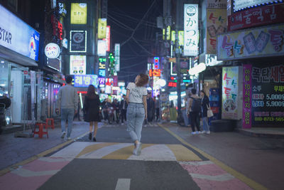 Rear view of woman walking on street in city